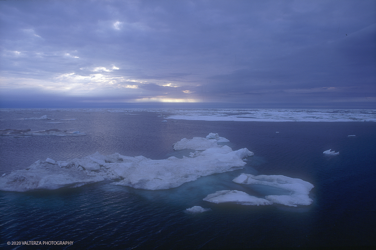 57 SIBERIA.jpg - Luglio/Agosto 1992. Siberia, terra dei Chukchi. Nell'oceano artico  125 Km a nord-est della penisola dei Chukchi (Siberia) c'Ã¨ l'isola di Wrangel, essa ospita piÃ¹ del doppio di specie vegetali (417) di qualsiasi territorio artico a paritÃ  di superficie nonchÃ¨ 30 specie diverse di uccelli oltre ad orsi polari, foche e trichechi ; per questo motivo   Ã¨ stata proclamata patrimonio dell'umanitÃ  dall'UNESCO. Nella foto Le luci dell'alba sul pack nel mare di Bering mentre si naviga verso l'isola di Wrangel